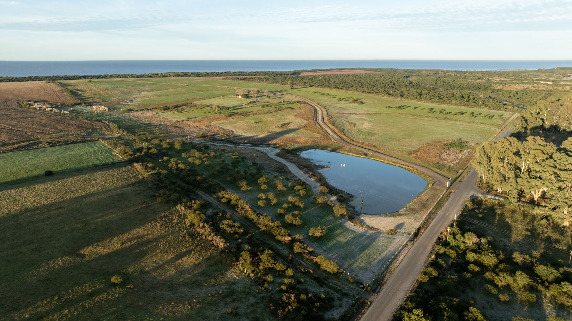 Vista aérea de las chacras con el Río de la Plata al fondo